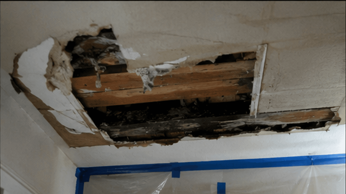 Ceiling opened after leak damage above a doorway